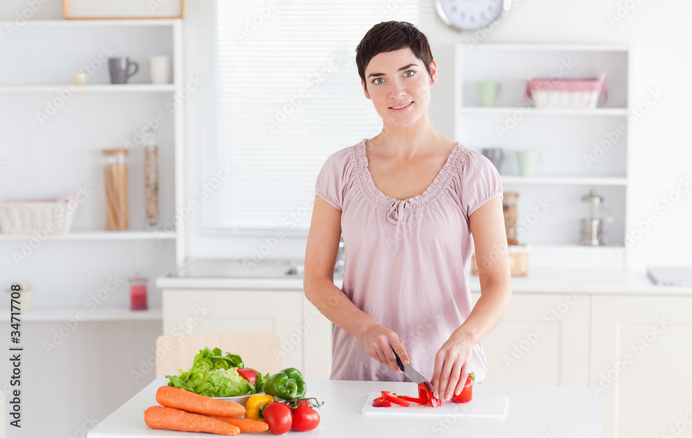 Smiling woman slicing vegetables Smiling woman slicing vegetables