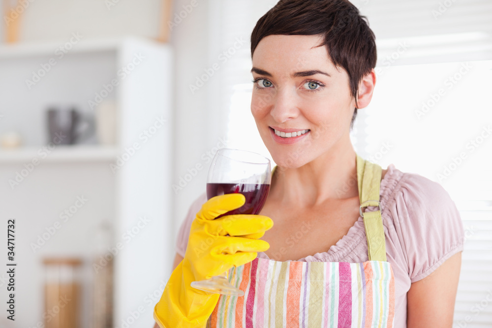 Beautiful woman drinking wine wearing cleaning gown Beautiful woman drinking wine wearing cleaning gown