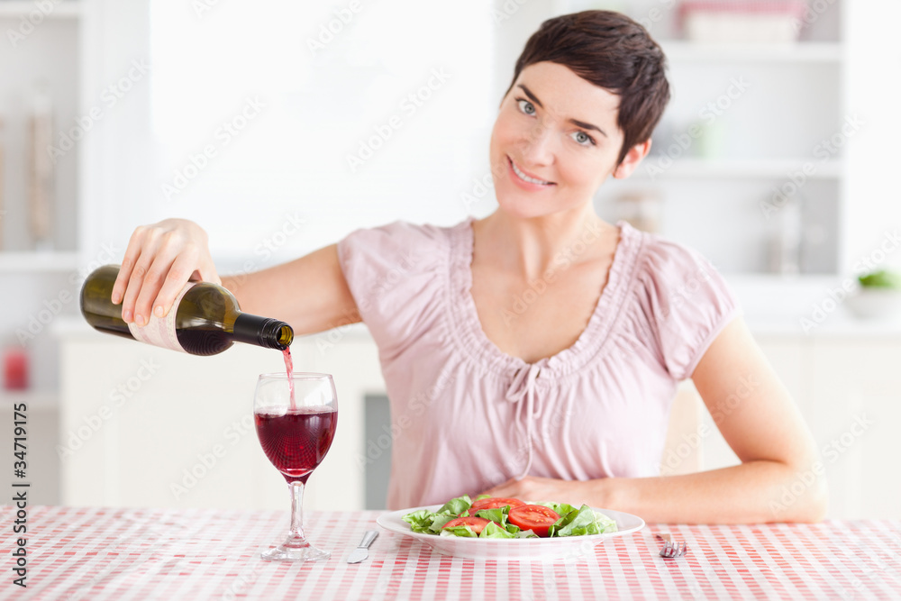 Woman pouring redwine in a glass Woman pouring redwine in a glass