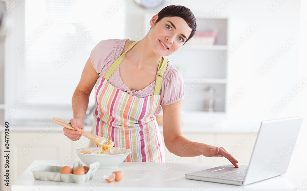 Charming Woman looking at a receipt on a laptop Charming Woman looking at a receipt on a laptop