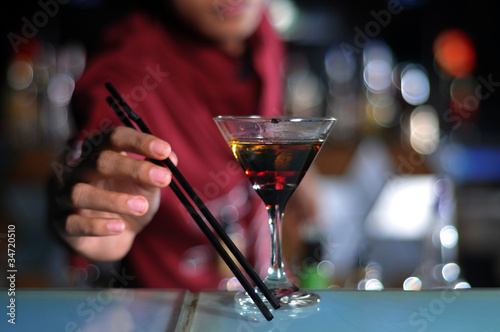 cocktail with bartender at background