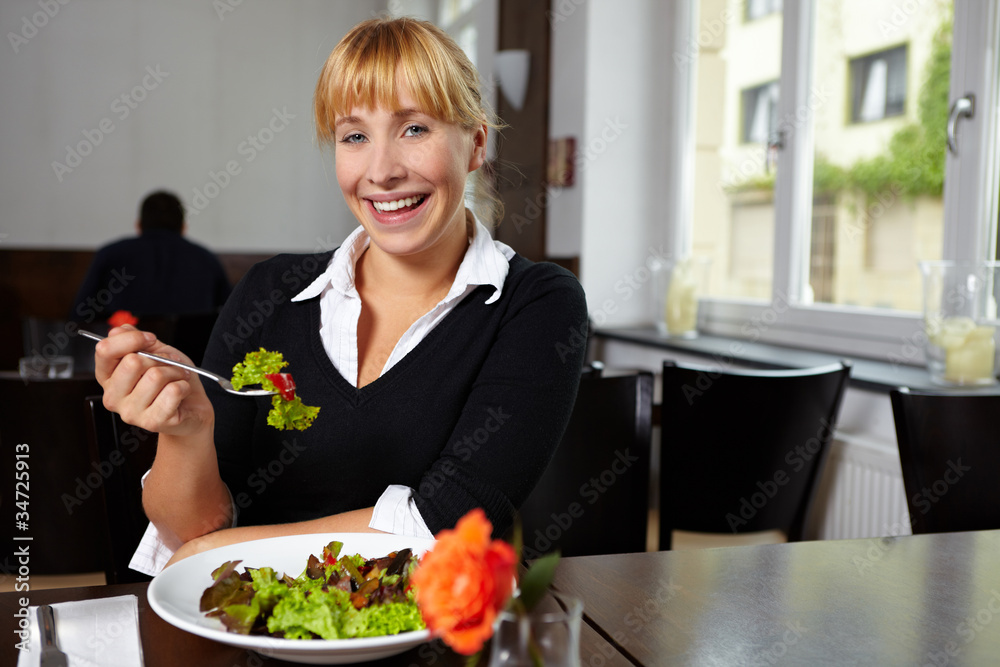 Lachende Frau im Restaurant mit Salat