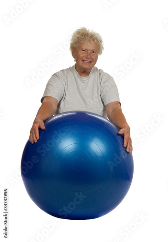 Senior woman with a fitball on white background