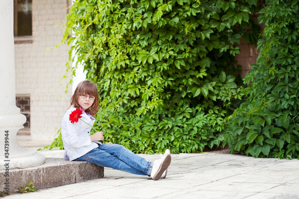 boy with a red flower in a hand sits on steps boy with a red flower in a hand sits on steps