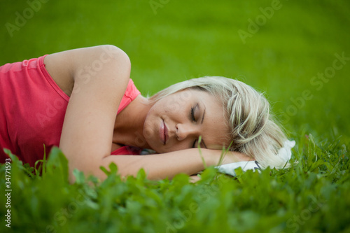 girl lying on the grass and sleeping peacefully