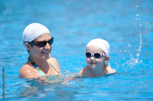 Mother and baby are swimming in swimming pool