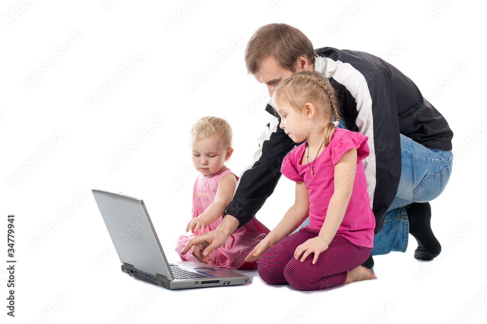 Father with children playing computer games on laptop