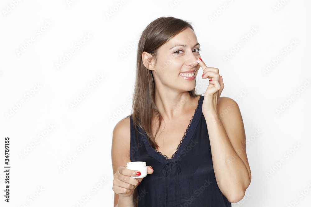Atrraktive Frau trägt Creme auf ihr Gesicht auf Atrraktive Frau trägt Creme auf ihr Gesicht auf