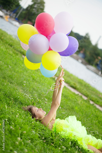 Woman holding bunch of colorful air balloons