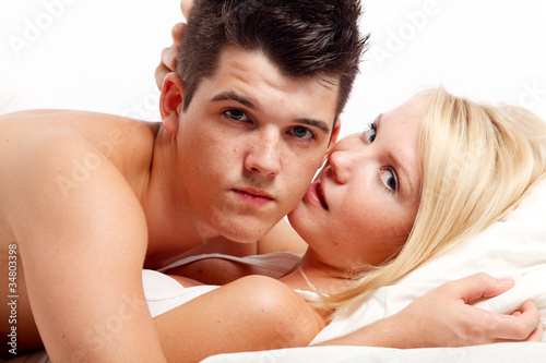 Loving affectionate heterosexual couple on bed.