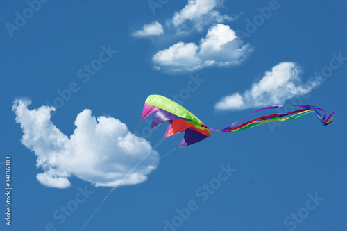 Colorful kite flying high among clouds