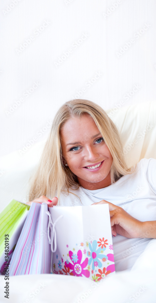 Young happy attractive girl unpack shopping bags in bedroom or h Young happy attractive girl unpack shopping bags in bedroom or h