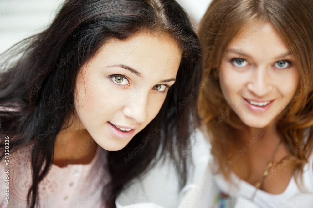 Two women whispering and smiling while shopping inside mall Two women whispering and smiling while shopping inside mall