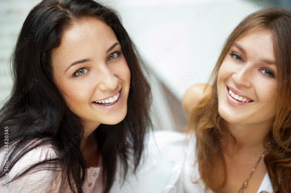Two women whispering and smiling while shopping inside mall Two women whispering and smiling while shopping inside mall