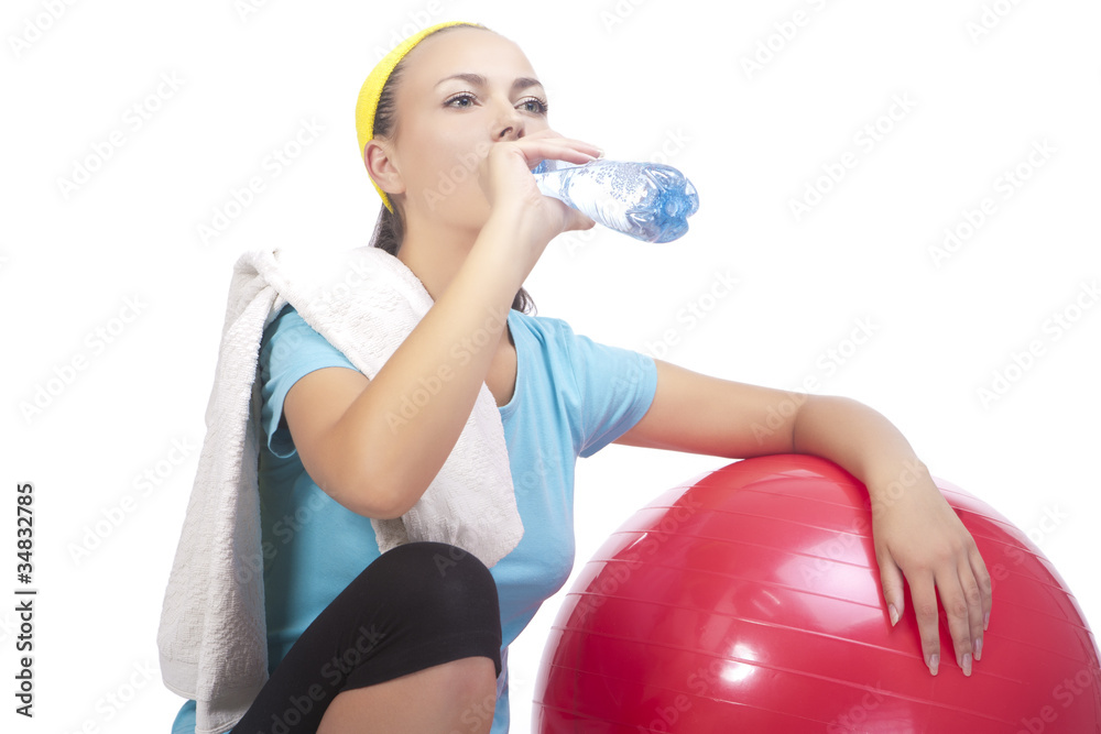 Fototapeta premium portrait of sportswoman drinking water after training with fitba
