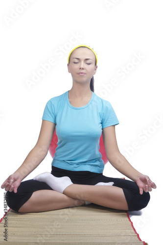 portrait of  brunette woman sitting on mat and doing yoga exerci © danmorgan12