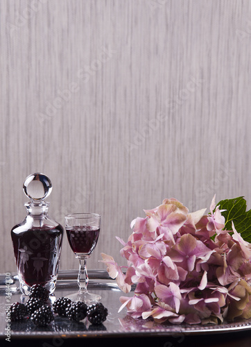 glass of cordial with carafe and hydrangea