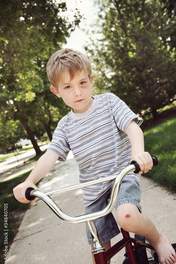 Obraz premium Young boy with injuries riding a bike