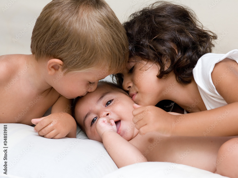 bambini che baciano un neonato bambini che baciano un neonato