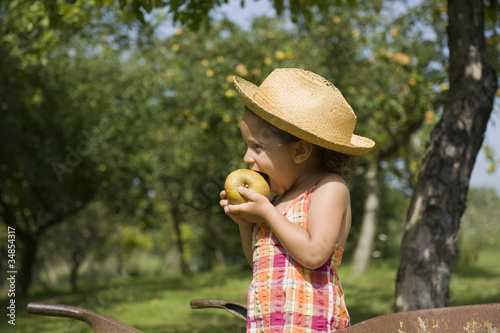 Jeune fille de profil croquant dans une pomme