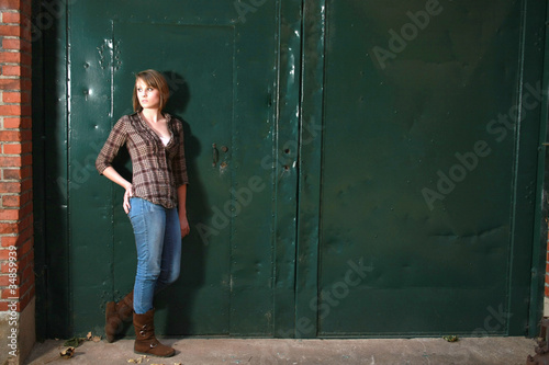 Younf woman standing by green doors