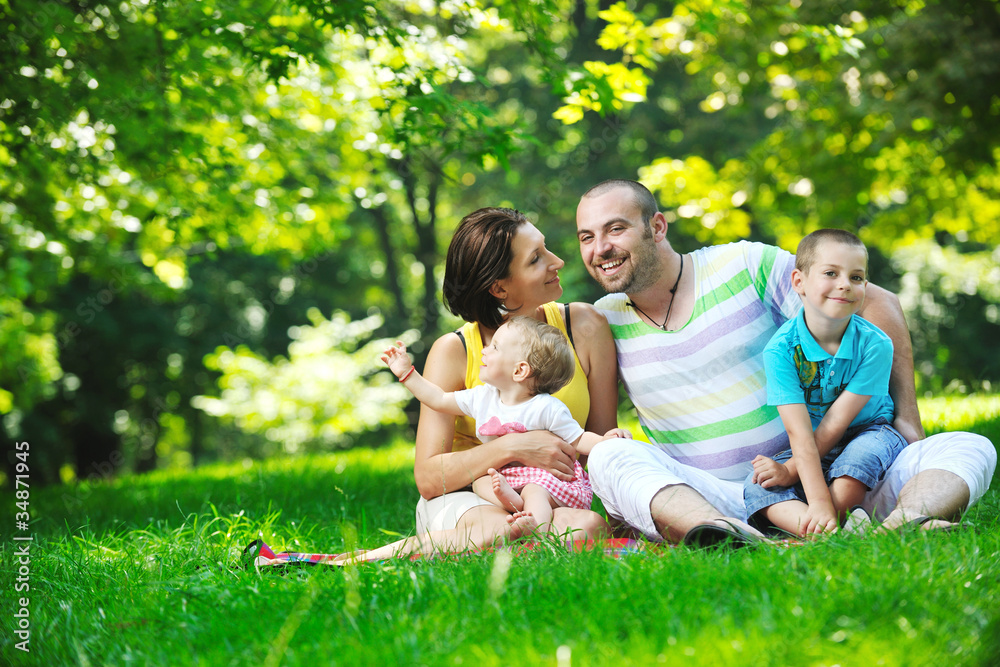 happy young couple with their children have fun at park