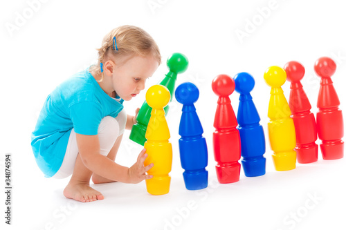 Little child is playing bowls in studio