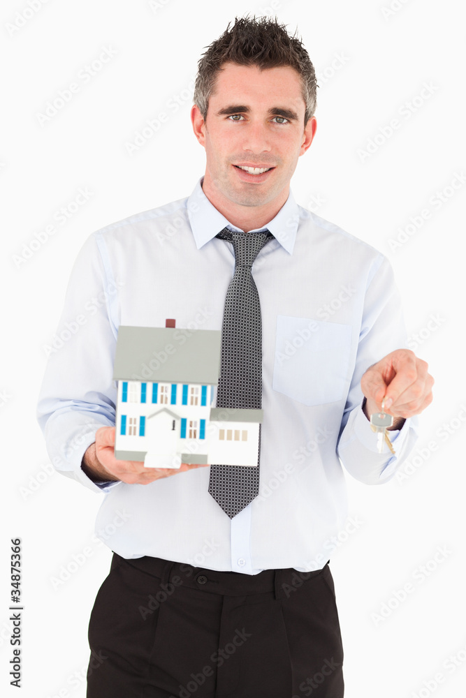 Businessman holding a key and a miniature house Businessman holding a key and a miniature house