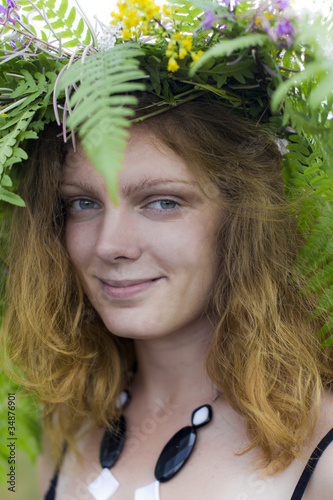 Close-up portrait of beautiful girl with floral wreath on a head