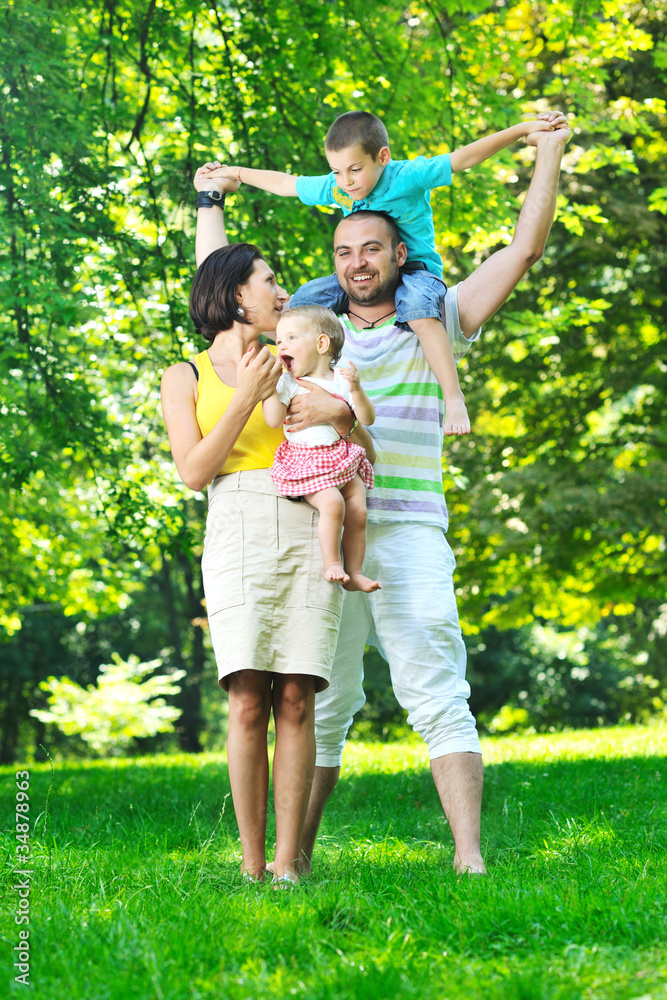 Fototapeta premium happy young couple with their children have fun at park