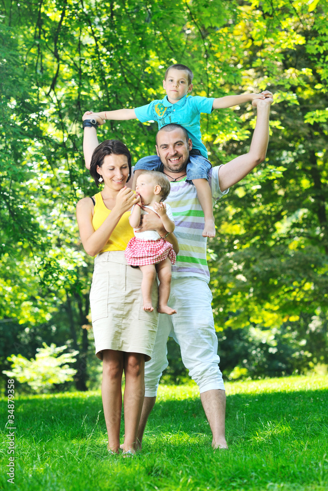 Fototapeta premium szczęśliwa młoda para z dziećmi bawić się w parku