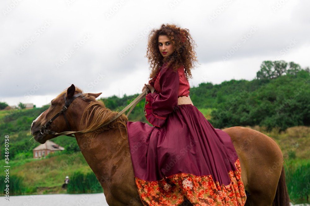 Beautiful gypsy girl riding a horse