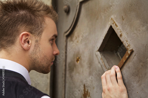 Handsome young man near an old metal door