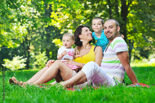 happy young couple with their children have fun at park