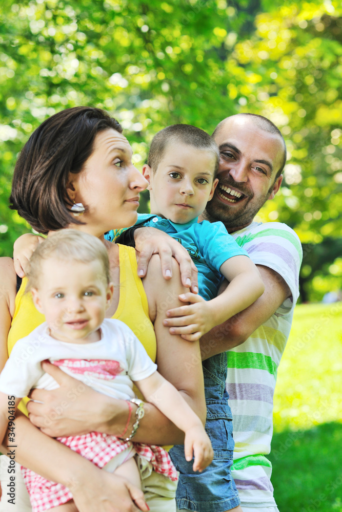 happy young couple with their children have fun at park happy young couple with their children have fun at park