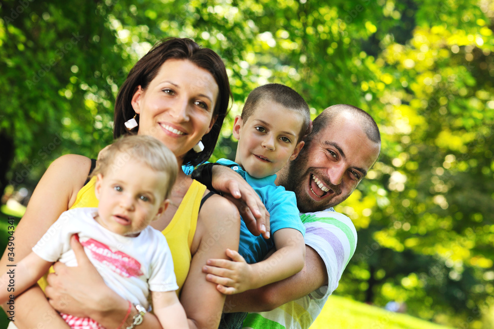 happy young couple with their children have fun at park happy young couple with their children have fun at park