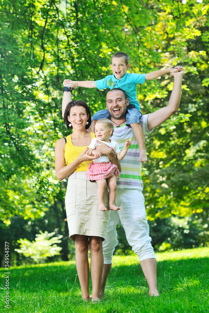Fototapeta premium happy young couple with their children have fun at park