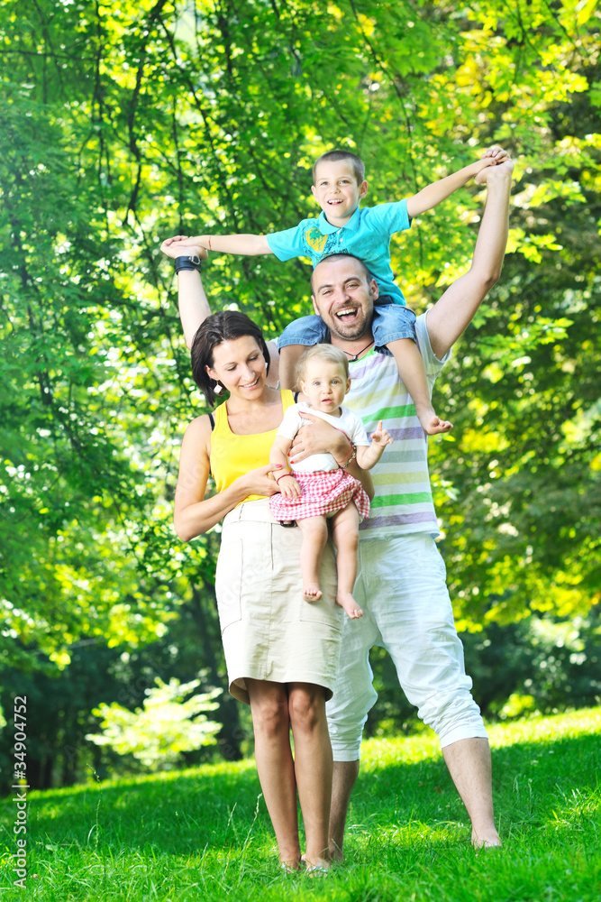 happy young couple with their children have fun at park happy young couple with their children have fun at park