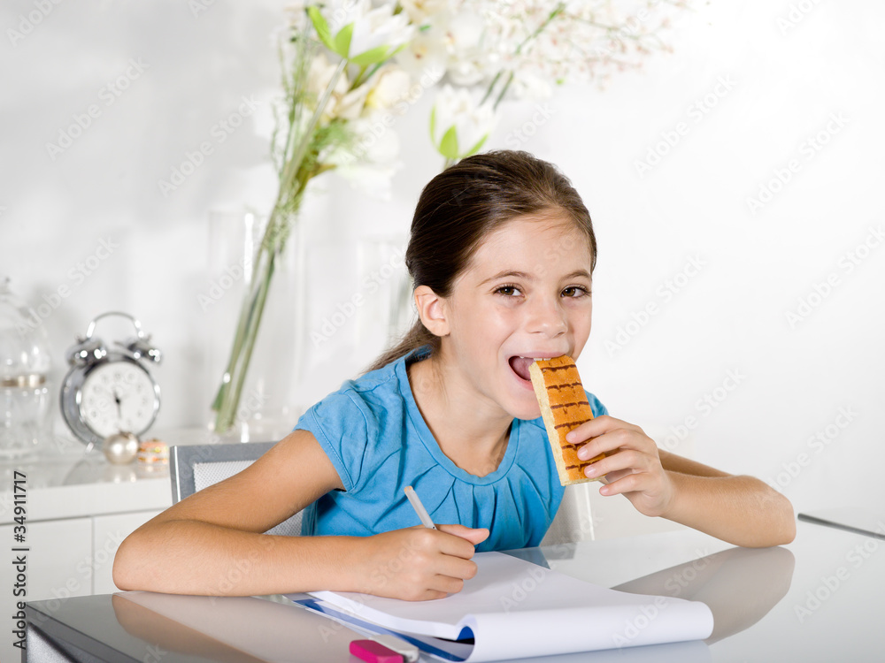 child eats snack while studying child eats snack while studying