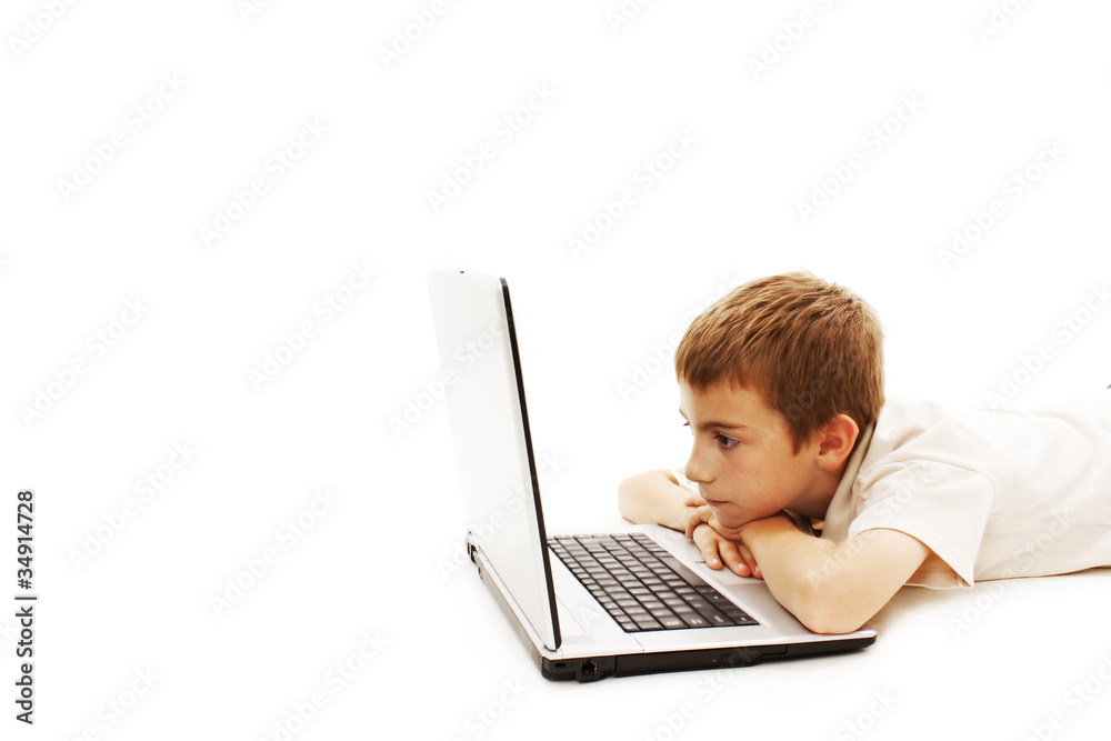 Young schoolboy is lying on floor with a laptop Young schoolboy is lying on floor with a laptop