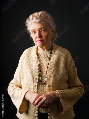 portrait of woman in her eighties on black background