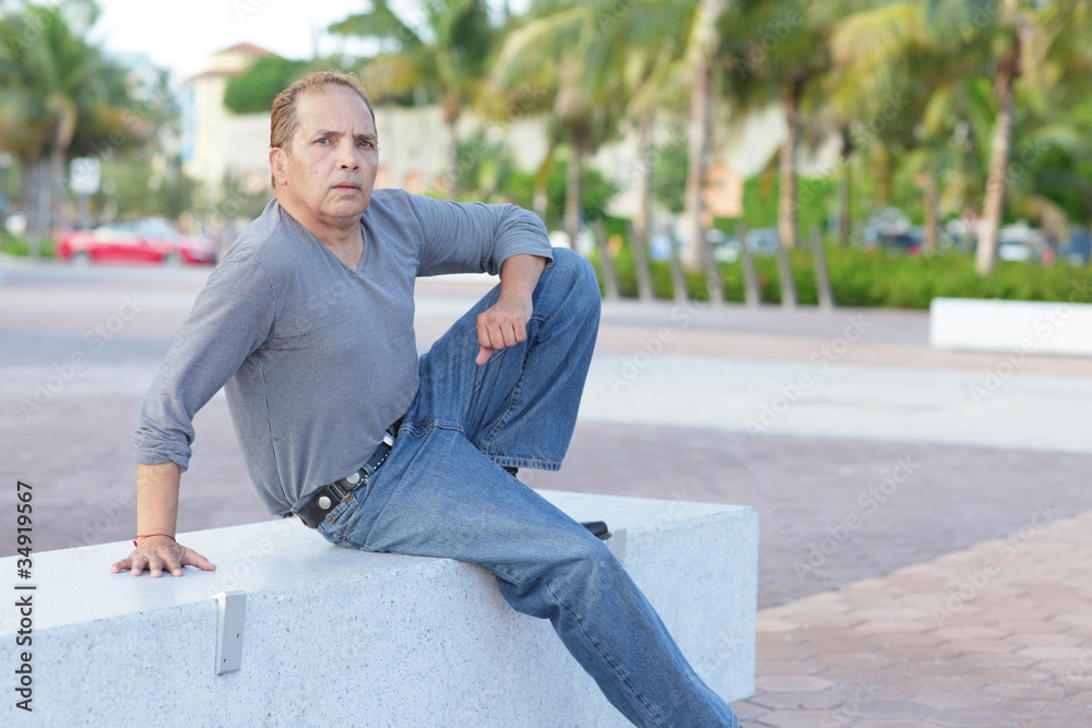 Fototapeta premium Mature adult sitting on a park bench