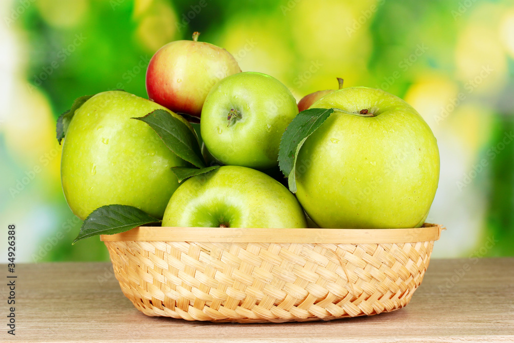 Fresh organic green apples in basket on wooden table outside Fresh organic green apples in basket on wooden table outside