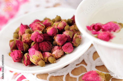 Dried rose flower heads and cup of tea
