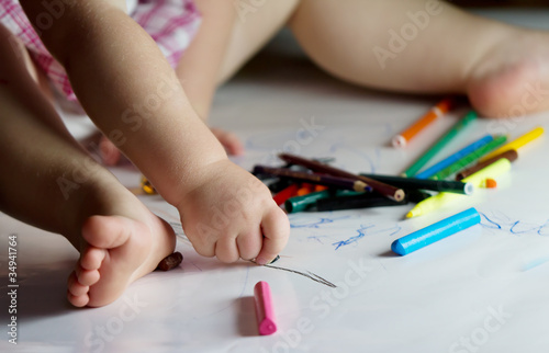 child draws with crayons