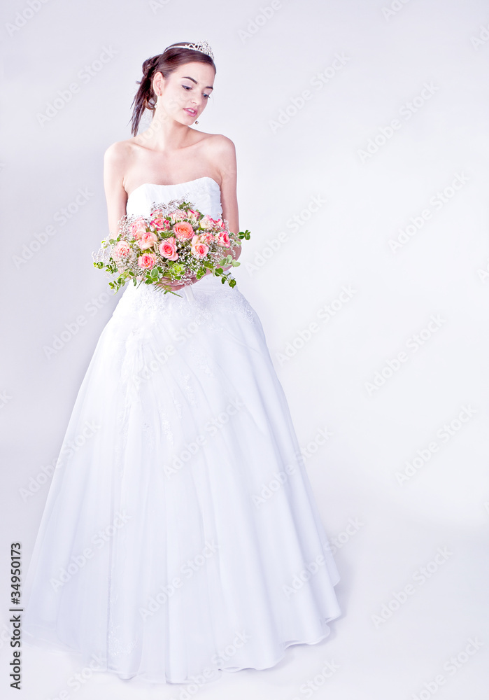 Woman in wedding dress with flowers' bouquet.