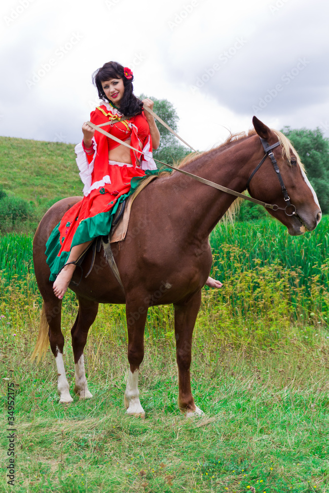 Beautiful gypsy girl riding a horse