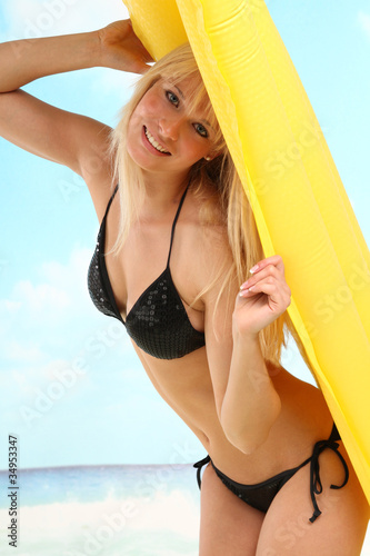 Frau mit Luftmatratze am Strand