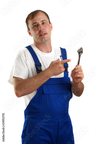 Handwerker mit blauer Latzhose hält einen Rollgabelschlüssel