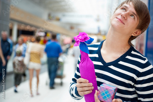 Portrait of young man inside shopping mall standing relaxed and